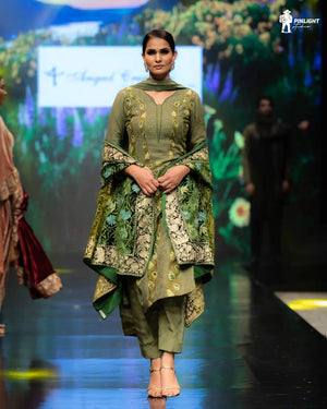 #Green Model wearing a green embroidered traditional outfit on a fashion show runway.