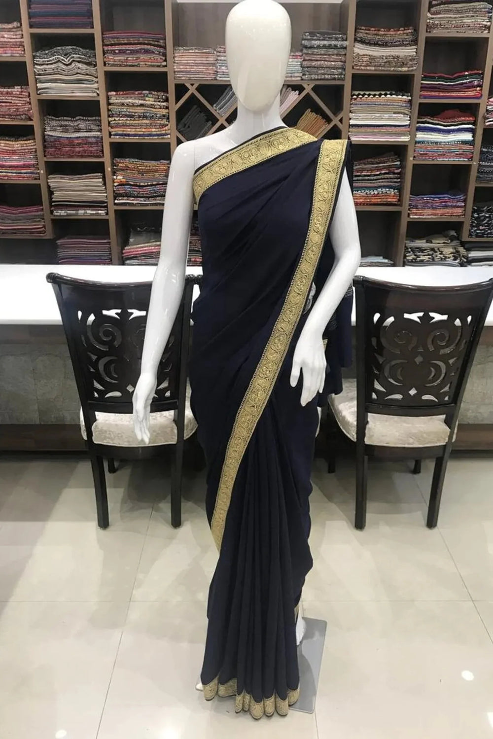 #NavyBlue Mannequin wearing a navy blue saree with gold border in a store setting.