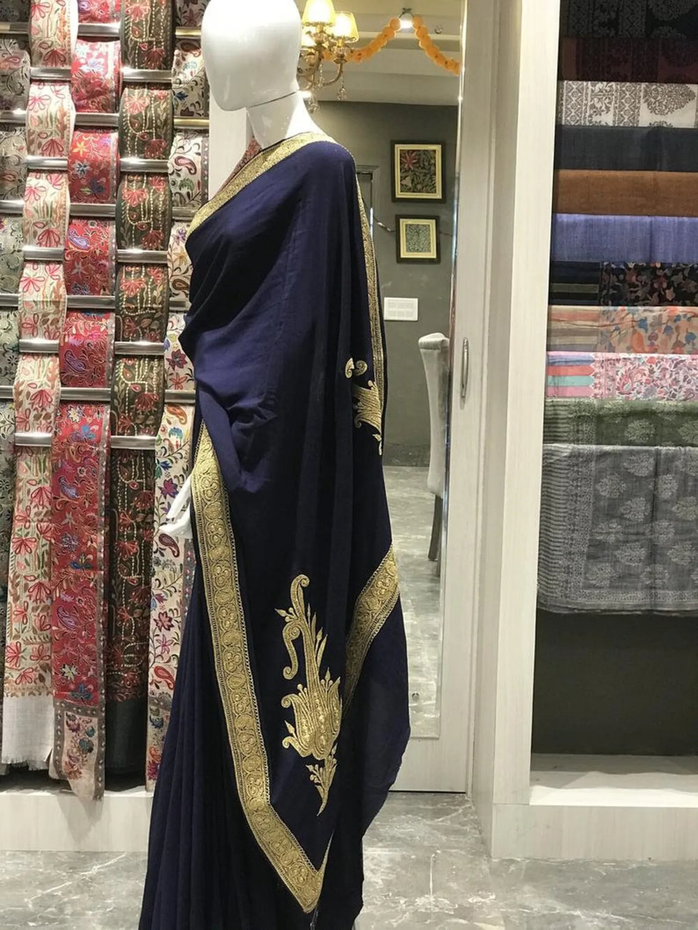 #NavyBlue Mannequin wearing a navy blue saree with gold border in a store setting.