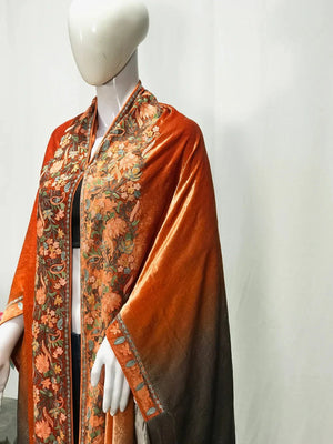 #Orange Mannequin wearing a rust-colored garment with floral patterns on a white background