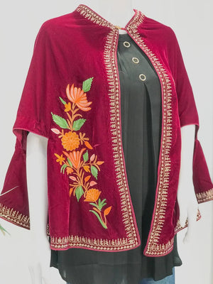 Red embroidered jacket over a black top on a white background