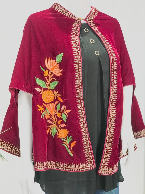 Red embroidered jacket over a black top on a white background