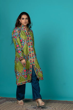 Woman wearing a colorful patterned kurta against a teal background
