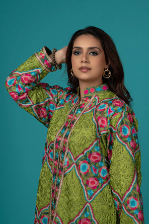 Woman wearing a green patterned outfit against a teal background