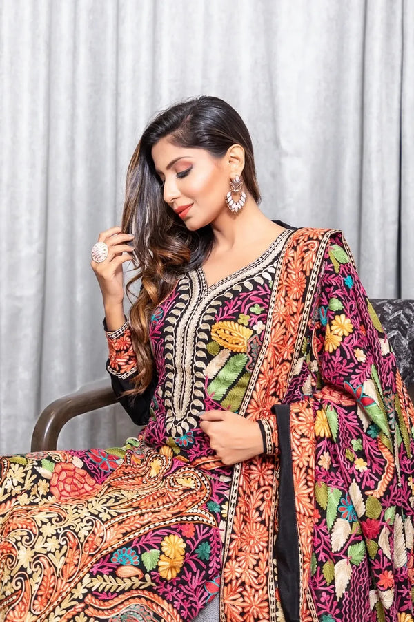 #Black Woman wearing a colorful embroidered traditional outfit with a white curtain background