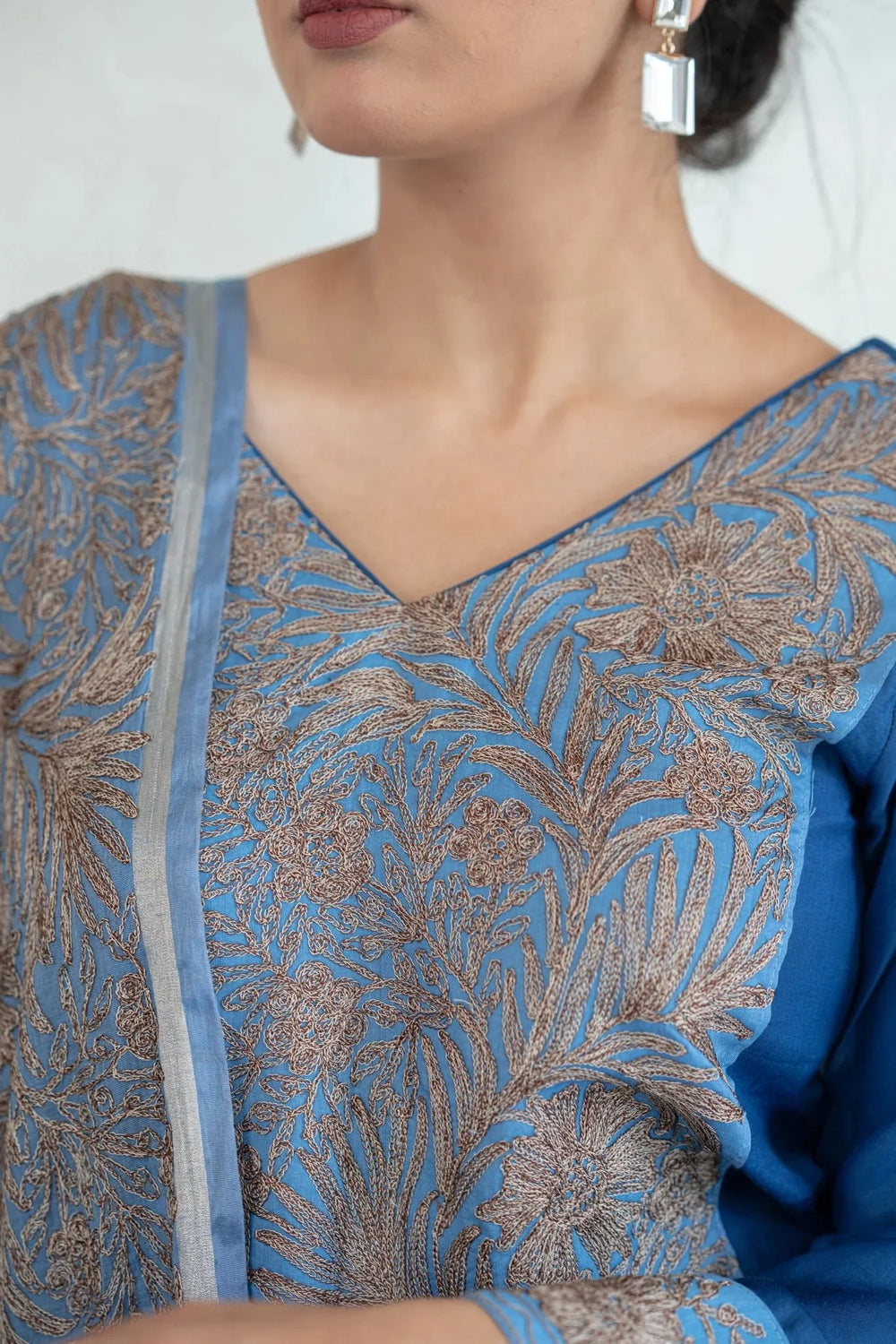 A woman modeling a floral embroidered straight kurta and pants set with a dupatta in a grey and blue color scheme.
#AquaBlue