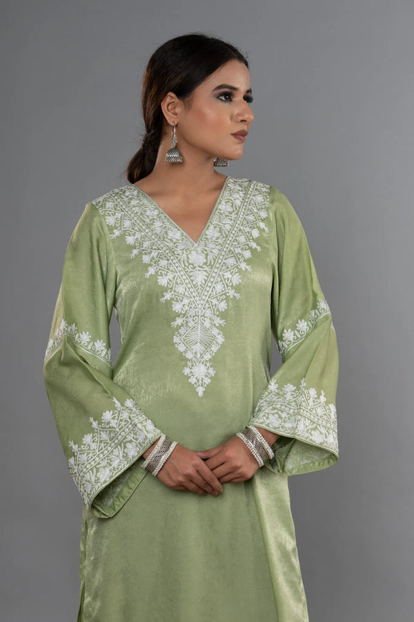 #MossGreen Woman wearing a green embroidered dress against a gray background