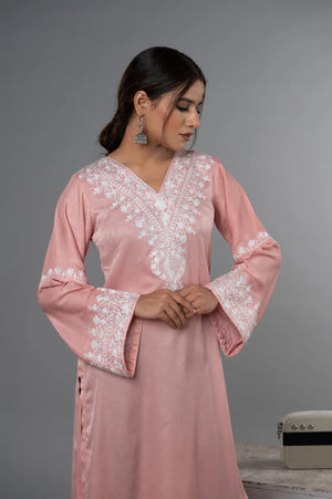 #BlushPink Woman wearing a pink dress with white lace details against a gray background