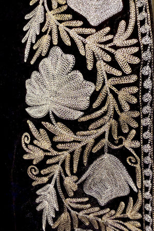 #Black Close-up of intricate floral embroidery on a black fabric background