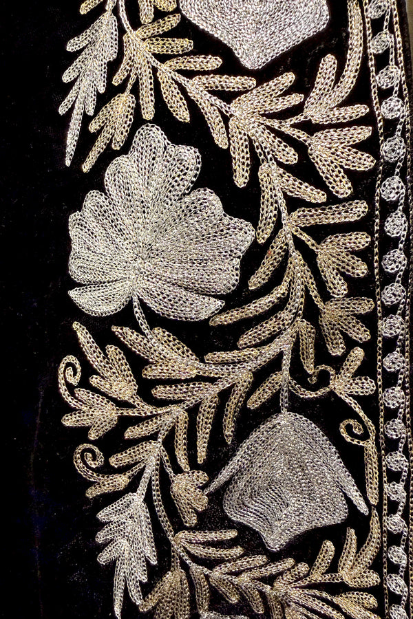#Black Close-up of intricate floral embroidery on a black fabric background