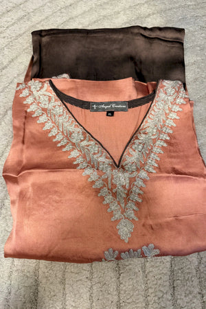 #OmbrePeach&Brown Peach and browncolored blouse with silver embroidery on a textured surface